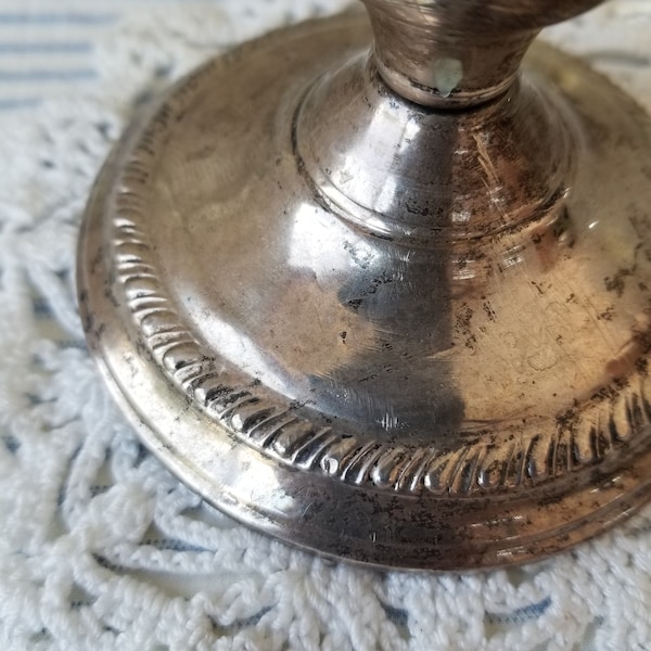 This aged heavy sterling silver candlestick is stamped nscu Sterling weighted. This Sterling waited Candlestick has suffered damage.