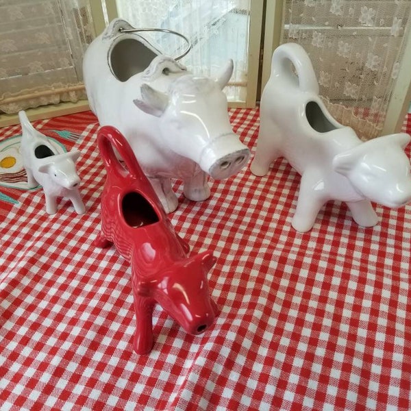 Charming assortment of varying sizes of Farmhouse cow creamers in white and red. Pick the one that suits your Farmhouse kitchen best.