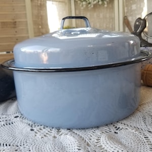 May include: A white ceramic mug with a black handle and the text "But First, Coffee" in a black, handwritten-style font. The mug is on a white surface.