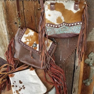 Your choice of three leather and cowhide cowgirl bags. Each of these beautiful purses are the perfect compliment for your Western outfit.