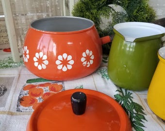 Delicious mid-century Orange fondue pot with wooden handle. This groovy fondue pot features the iconic 1960 flower power design.