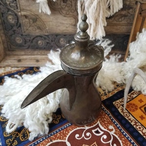 Antique hand soldered Middle Eastern dallah. This antique brass and copper Bedouin coffee dallah is filled with mysterious Bohemian charm.