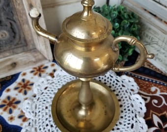 Intriguing Bedouin inspired brass hand held oil lamp. This small Alladin style brass oil lamp will really shine in your Bohemian home.