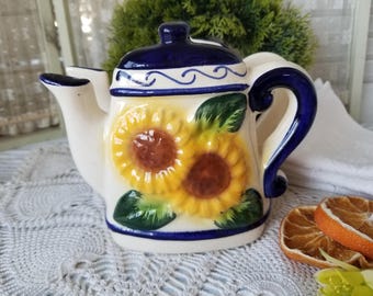 Servilletero con forma de tetera de girasol, bonito y colorido. Este adorable servilletero de cerámica azul y amarillo con forma de tetera es perfecto para tu mesa de campo.