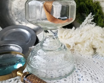 This antique P&A Mfg clear glass oil lamp is perfect Farmhouse decor. This tall footed antique glass oil lamp has a coveted eagle burner.