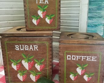 Adorable strawberry imbued wooden canister set. These three  Woodcrest dovetail wooden canisters are perfect for any farmhouse kitchen.