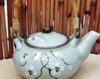 Lovely diminutive Pottery Japanese teapot. This gorgeous teapot features hand-painted Sakura cherry blossoms and a bamboo handle.