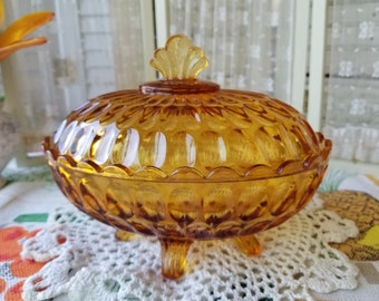 Gorgeous amber glass candy dish. This lovely mid-century vintage amber depression glass candy dish has a scalloped knob on the handle.