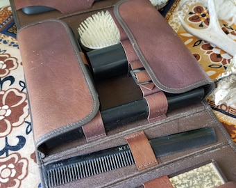 Vintage man's grooming kit. A stylish guaranteed genuine steerhide holds a 7 piece aged gentleman's shaving toiletry kit.