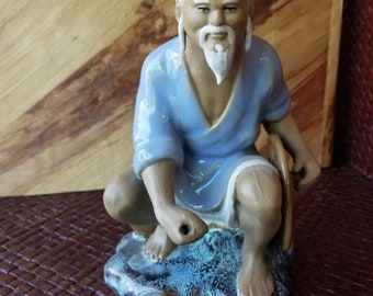 This midcentury Chinese mudman seems to be enjoying his day. Gentle soothing colors abound on this wise old chinese clay figurine.