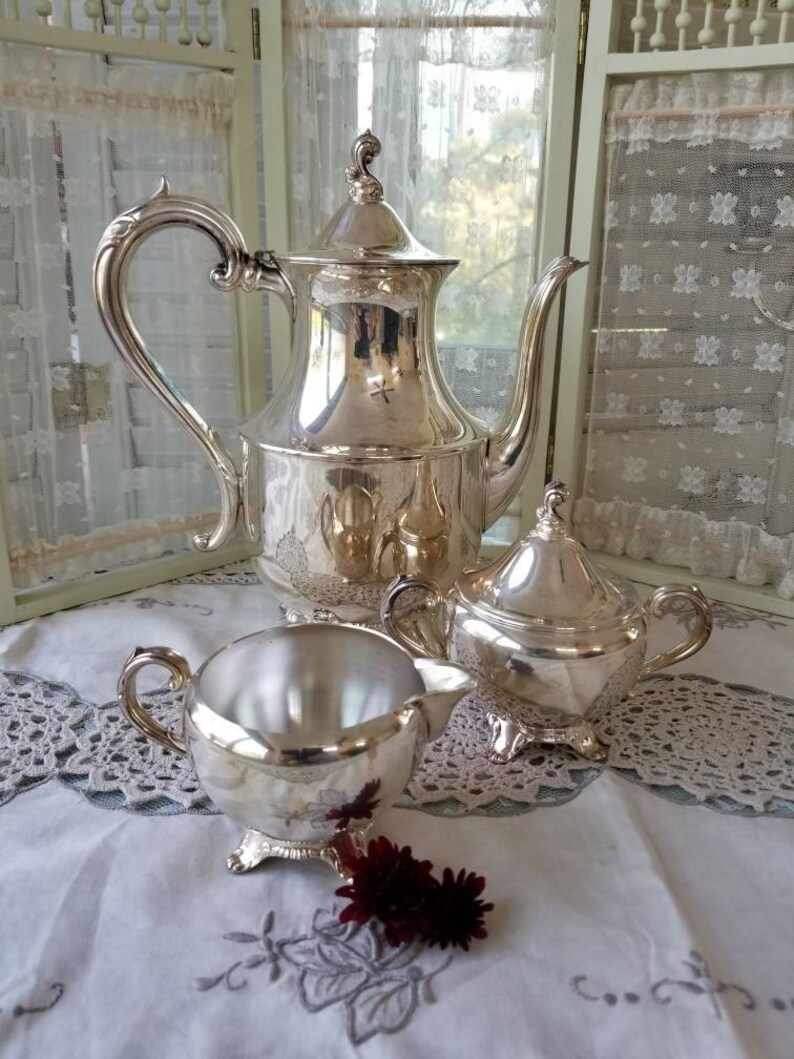 Glorious and gleaming silver plated William Rogers coffee pot and accompanying sugar and creamer. This shops beautiful 3 piece set speaks Elegance