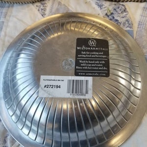 Puede incluir: Platos de servir de metal plateado con un dise&ntilde;o acanalado. Los platos tienen un borde decorativo y una etiqueta que dice "WILTON ARMETALE" y "FLUTES&PEARLS SM C&D #272194".