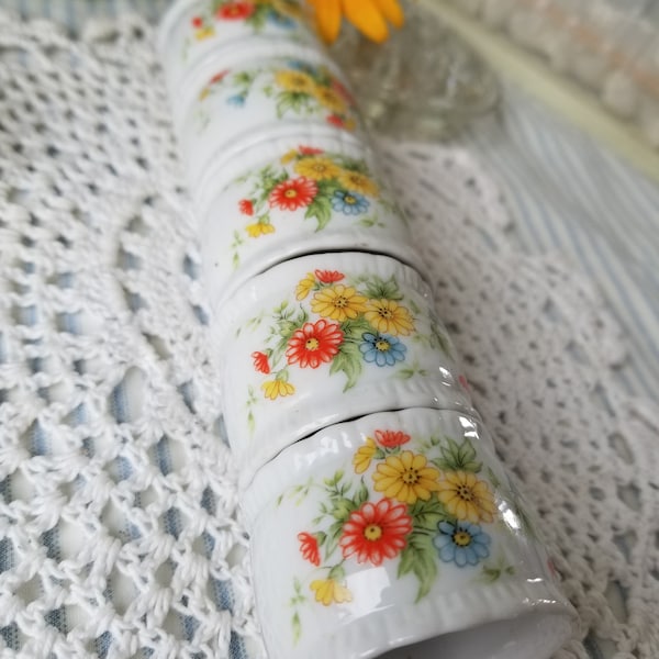 Lovely cottage core ceramic napkin rings. This set of five White ceramic napkin rings each feature a beautiful bunch of bright flowers.