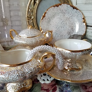 Absolutely stunning hand painted gold teacup, 2saucers, 1 bread plate and creamer and sugar set. These 6 golden beauties are very elegant.