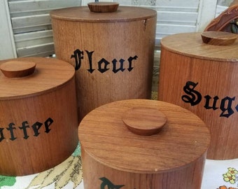 Iconic 1960s era solid wood kitchen cannisters.  Midcentury charm shines in this four piece vintage set of round solid wood cannisters.