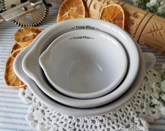 Adorable set of white ceramic pouring measuring cups. These 3 nesting  measuring cups would look sweet  in your cottage kitchen!
