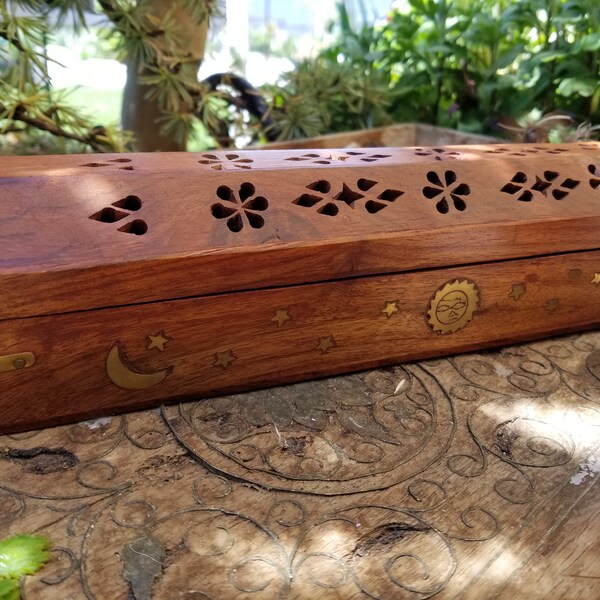 Beautiful brass inlaid carved teak wood incense box. This gorgeous incense box has been decorated with inlaid brass sun, stars, and moon.