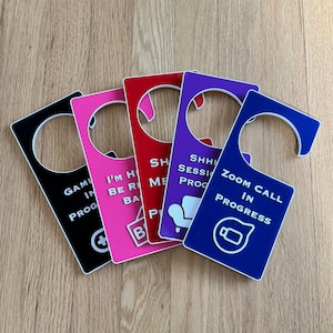 May include: Five different door hangers with various messages. The messages include "Gaming in Progress", "I'm Home Be Right Back", "Shh Meeting in Progress", "Shh Session in Progress", and "Zoom Call in Progress".