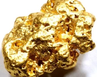 Puede incluir: Una pepita de oro grande e irregular. El oro es de un amarillo brillante y tiene una superficie rugosa y texturizada.