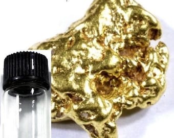 May include: A small glass vial with a black lid containing a large, irregular nugget of gold. The gold nugget is a bright, shiny yellow color and has a rough, textured surface.
