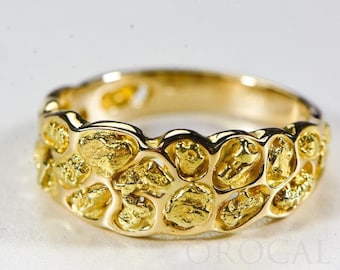 May include: A gold ring with a unique design featuring a textured surface that resembles a nugget of gold. The ring is wide and has a rounded shape.