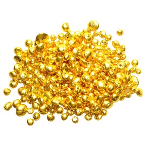 May include: A pile of shiny, golden nuggets, likely gold, on a white background.