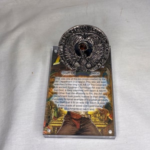 Indiana Jones, tysk Toht RA-huvudbonad, silver, metall, djungelstaffili, akrylskylt, riktig rekvisitakopia