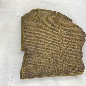Könnte beinhalten: Eine Nachbildung des Rosetta-Steins, eine dunkelgrüne Steinplatte mit alten ägyptischen Hieroglyphen, demotischer Schrift und griechischem Text.