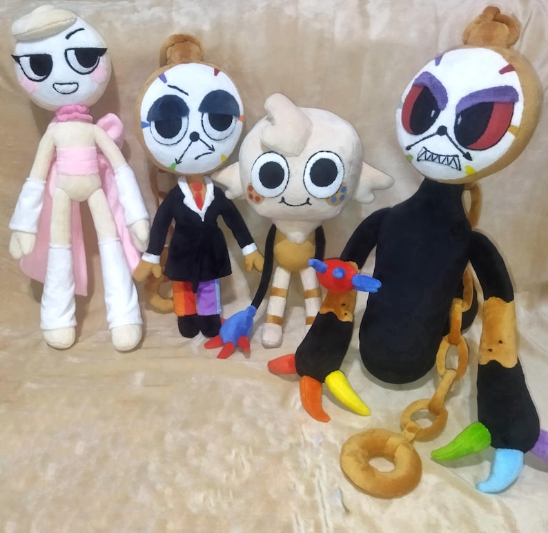 Peut inclure: Plusieurs poup&eacute;es en peluche faites &agrave; la main avec des visages expressifs uniques. Chaque poup&eacute;e pr&eacute;sente un design distinct, avec des tenues et des accessoires vari&eacute;s, dont un costume noir, une cape rose et une queue color&eacute;e. Les poup&eacute;es sont en tissu doux et ont des traits faciaux d&eacute;taill&eacute;s.
