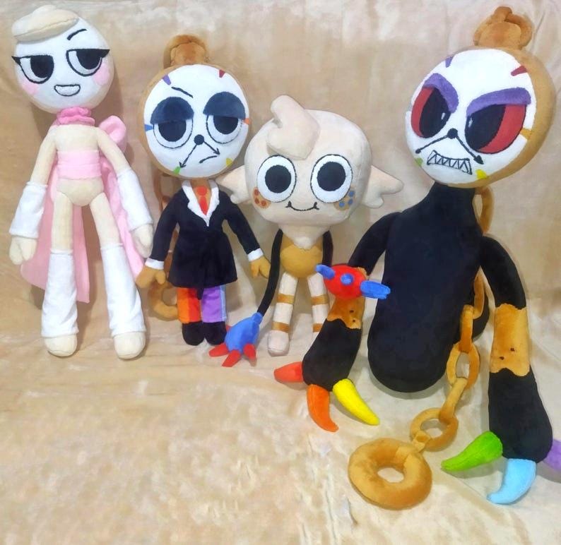 May include: A collection of four plush dolls. The first is a white figure with pink accents. The second is a clock-faced character in a black suit. The third is a small beige creature with large eyes. The fourth is a large black and gold figure.