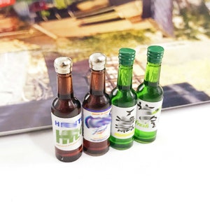Puede incluir: Cuatro botellas de vidrio en miniatura con tapas plateadas. Dos botellas son marrones con etiquetas blancas y el texto "HEIT" y "Fresh". Dos botellas son verdes con etiquetas blancas y el texto "Fresh".