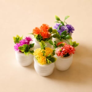 Puede incluir: Seis pequeñas macetas de cerámica blanca contienen cada una un arreglo floral de diferente color. Las flores son en tonos naranja, morado, rosa, amarillo y rojo, con hojas verdes. Las macetas están dispuestas sobre una superficie de color beige claro.