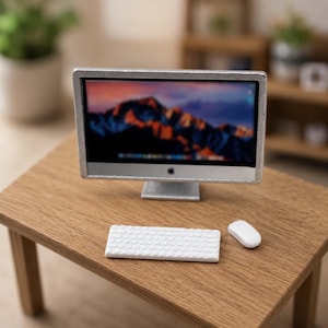 Peut inclure: Un écran d'ordinateur de bureau miniature de couleur argentée avec un écran noir affichant un paysage de montagne, accompagné d'un petit clavier rectangulaire blanc et d'une souris d'ordinateur blanche, disposés sur une surface en bois.