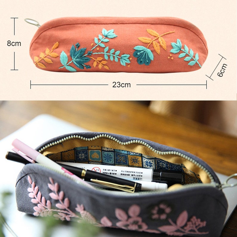 May include: A gray and orange pencil case with floral embroidery. The case is 23 cm long, 8 cm tall, and 6 cm wide. The case is open to reveal a yellow and blue patterned lining.