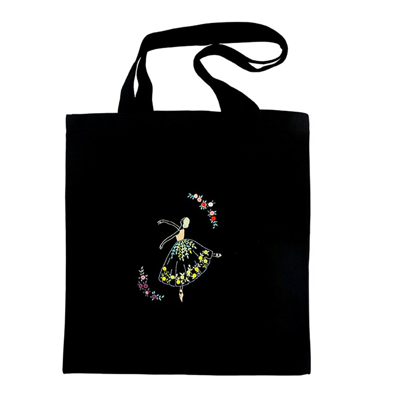 May include: Black tote bag with a white embroidered ballerina in a yellow and green dress surrounded by a circle of colorful flowers.