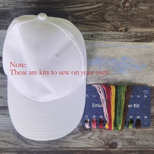 May include: White baseball cap embroidery kit with a blue floral design on white fabric, a card with 9 spools of embroidery floss, and the text "Note: These are kits to sew on your own" in red.