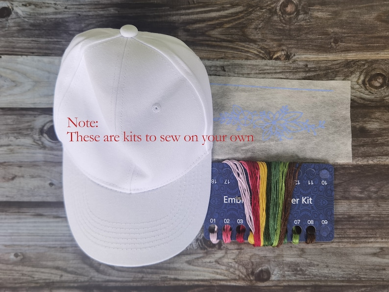 May include: White baseball cap embroidery kit with a blue floral design on white fabric, a card with 9 spools of embroidery floss, and the text "Note: These are kits to sew on your own" in red.