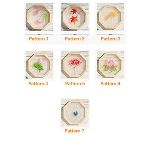 Peut inclure: Sept motifs de broderie dans des cadres octogonaux. Les motifs comprennent des fleurs, des feuilles et des papillons. Les cadres sont en bois et ont une finition naturelle.
