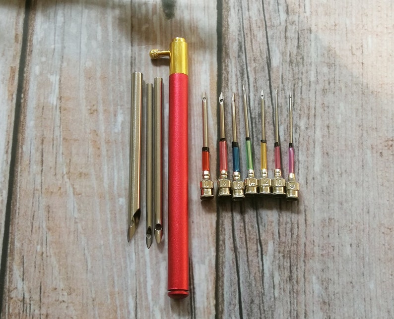 May include: A set of 10 embroidery needles with different colored tips and a red needle threader tool. The needles are numbered 1 to 10.