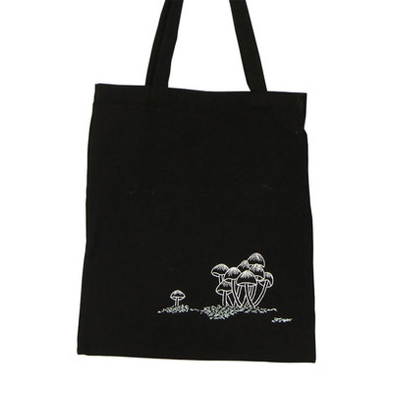 May include: Black canvas tote bag with a white embroidered design of mushrooms.