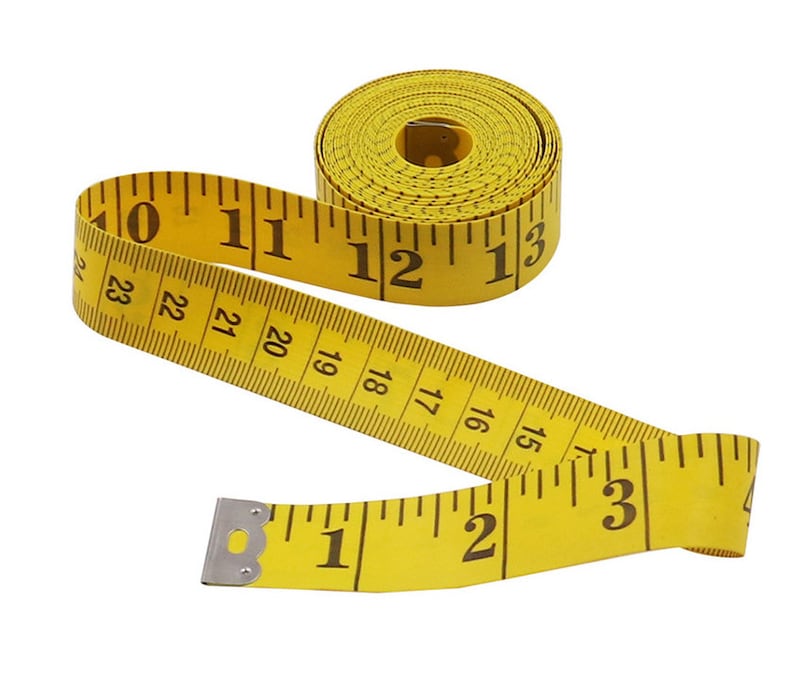 May include: A yellow measuring tape with black markings and numbers. The tape is rolled up and partially unrolled, showing numbers from 1 to 23.