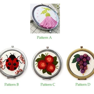 Op de afbeelding: Vier geborduurde compact spiegels met verschillende ontwerpen. De eerste spiegel heeft een roze distel, de tweede een rode lieveheersbeestje, de derde een bos rode rozen en de vierde een tros paarse druiven.