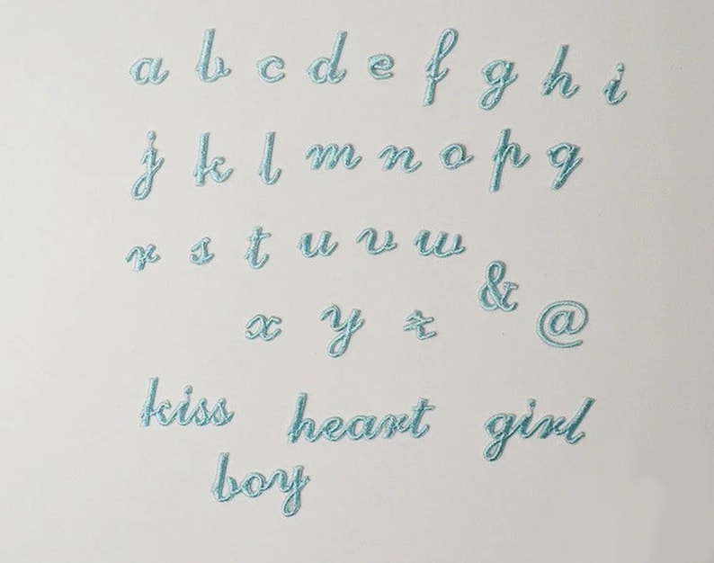 May include: A set of light blue embroidered iron-on patches featuring the alphabet, ampersand, at symbol, and the words "kiss", "heart", "girl", and "boy".