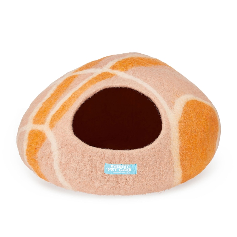 K&ouml;nnte beinhalten: Eine abgerundete, gefilzte Haustierh&ouml;hle in hellen Beige- und leuchtenden Oranget&ouml;nen mit einer gro&szlig;en kreisf&ouml;rmigen &Ouml;ffnung. Ein kleines, rechteckiges hellblaues Etikett auf der Vorderseite tr&auml;gt den wei&szlig;en Text EVEREST PET CAVE. Das Innere ist dunkelbraun.
