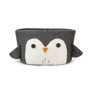 May include: A gray felt penguin-shaped storage basket with a white felt face and orange beak.