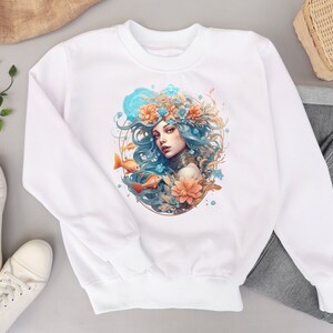 May include: White sweatshirt with a colorful illustration of a woman with long blue hair wearing a floral crown and surrounded by flowers and fish.