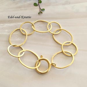 Può includere: Un braccialetto dorato fatto di maglie ovali intrecciate. Il braccialetto ha una chiusura a moschettone.