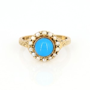 May include: A gold ring with a blue gemstone surrounded by a halo of white pearls.