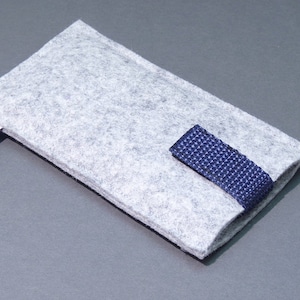 May include: A gray felt phone case with a blue strap. The case has a small purple owl logo on the side.