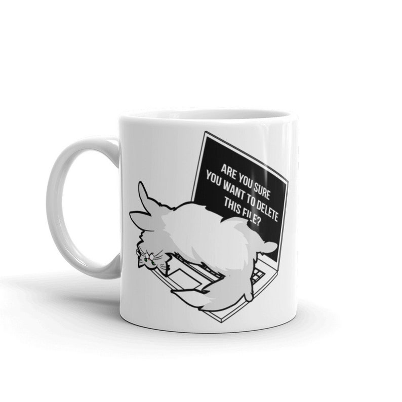 May include: White ceramic mug with a black and white illustration of a cat on a laptop. The laptop screen displays the text "Are you sure you want to delete this file?"